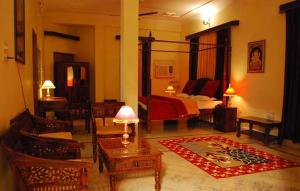 Una sala de estar con un dormitorio con una cama y una alfombra. en Pratapgarh Haveli, en Bundi