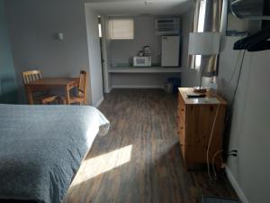1 dormitorio con cama, escritorio y mesa en Fireweed Motel en Smithers