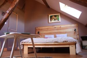 Schlafzimmer mit einem Bett mit einem Kopfteil aus Holz in der Unterkunft Une Parenthèse en Champagne in Jaucourt