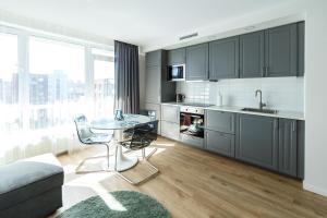 a kitchen with gray cabinets and a table with chairs at Spacious apartment close to the Old Town in Vilnius