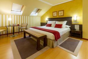 Habitación de hotel con cama, mesa y sillas en Hotel MIRAVALLE, en Ourense
