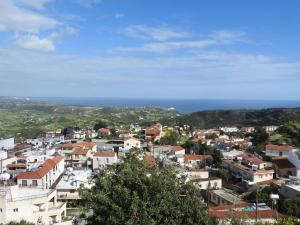 a view of a town with the ocean in the background at Hill View Hotel Apartments in Pissouri