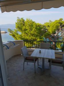 a table and chairs on a balcony with a view of the ocean at Guesthouse Marina in Tučepi