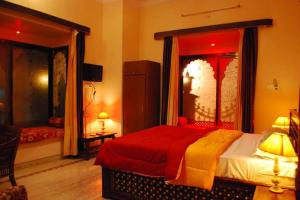 1 dormitorio con 1 cama con manta roja y amarilla en Pratapgarh Haveli, en Bundi 4 fotos más