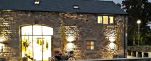 - un bâtiment en pierre avec une grande porte en verre dans l'établissement Lancaster Barn, à Lancaster