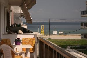 balcón con mesa y sillas y vistas a la playa en Luminous Apartment en Agia Triada