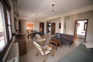 salon z kanapą, krzesłami i stołem w obiekcie Luminous Apartment w mieście Agia Triada