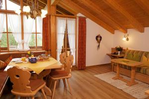 a dining room with a wooden table and chairs at Haus am Schmiedweg in Reit im Winkl