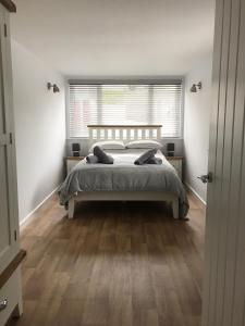 Un dormitorio blanco con una cama y una ventana. en Talland Studio, en St Ives