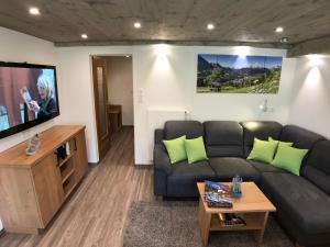 a living room with a couch and a flat screen tv at Gästehaus Amort Ferienwohnung in Ramsau