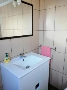 a bathroom with a white sink and a mirror at Casa dos biscoitos in Madalena