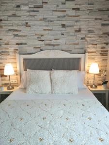 奧林匹亞達的住宿－Casa Alegria，一间卧室配有一张带两盏灯的大型白色床。