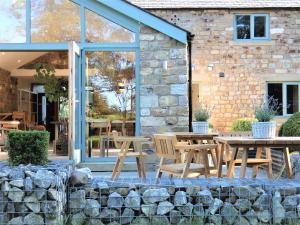 un patio avec des tables et des chaises en face d'un bâtiment dans l'établissement Lancaster Barn, à Lancaster