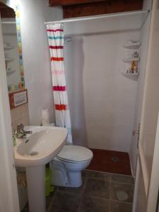 a small bathroom with a toilet and a sink at Casita De Gato in Tahiche