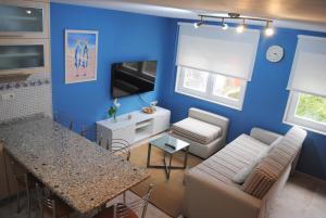a blue living room with a couch and a table at Dúplex A Moa in O Pindo