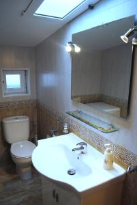 a bathroom with a sink and a toilet and a mirror at Dúplex A Moa in O Pindo
