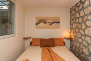 a bed in a room with a stone wall at Apartments Mirian in Petrovac na Moru +79 photos