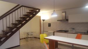 uma cozinha com uma escada e uma mesa com cadeiras em Slow Umbria 05039 em Stroncone