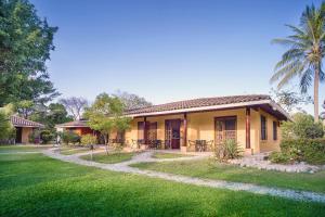 a small yellow house with a grass yard at Hotel Boutique Bahia Esmeralda in Potrero