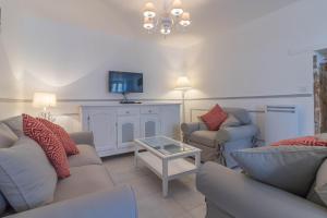 ein Wohnzimmer mit 2 Sofas und einem TV in der Unterkunft Gîte le Cocoon d'Isatis 1 in Montgiscard