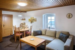 a living room with a couch and a table at Chaloupka Slaměnka in Loučná pod Klínovcem