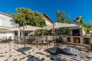 a patio with tables and umbrellas and a fireplace at Villa Mara in Crikvenica