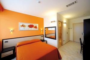 ロッカ・サン・ジョヴァンニにあるHotel Cristinaのベッドルーム(オレンジ色のベッド1台、鏡付)