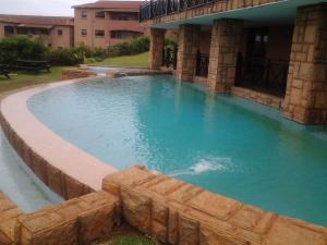 a swimming pool in a building with blue water at Ocean View Villas Unit G02 in Port Edward