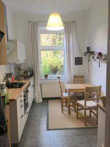 eine Küche mit einem Tisch und Stühlen sowie einem Fenster in der Unterkunft Feldstraße 10 in Lüneburg