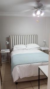 1 dormitorio con 1 cama grande y 2 mesas en Innes Road Durban Accommodation 2 bedroom private unit, en Durban