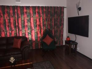 a living room with a couch and a red curtain at Overmeer in Worcester