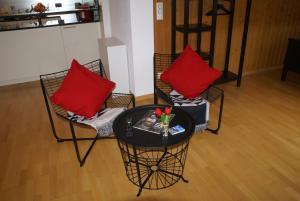 zwei Stühle und ein Tisch mit zwei roten Kissen in der Unterkunft Matten Central Studio in Matten + 3 Fotos