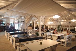 a restaurant with tables and people sitting at tables at Hotel Laguna in Lozenets
