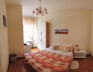 1 dormitorio con cama y lámpara de araña en Assarotti Centre Apartment, en Génova