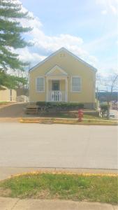 a yellow house with a fire hydrant in front of it at Harbor Haus Inn & Suites in Hermann