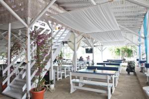 a restaurant with white tables and chairs and white umbrellas at Hotel Laguna in Lozenets