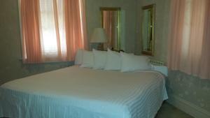 ein Schlafzimmer mit einem großen weißen Bett mit weißen Kissen in der Unterkunft Harbor Haus Inn & Suites in Hermann