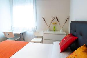a bedroom with a bed and a table and a chair at Apartamentos Duque in Madrid