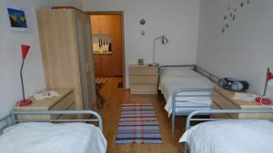 a room with three beds and a hallway at Apartman pod Dedovkou in Oščadnica