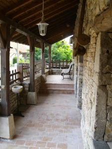 un patio extérieur avec un mur en pierre et un banc dans l'établissement La chaumière de Laives, à Laives