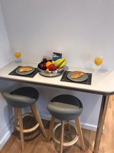 una mesa de desayuno con 2 vasos de zumo de naranja y fruta en Talland Studio, en St Ives