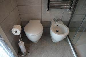 een badkamer met een toilet, een bidet en een wastafel bij Brenin in Varazze