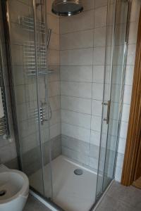 een douche met een glazen deur naast een toilet bij Brenin in Varazze