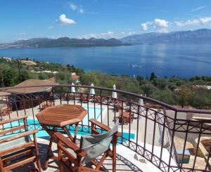 a balcony with a table and chairs and a view of a lake at Anastasia Village in Nikiana