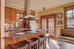 uma cozinha com uma grande ilha com bancos de bar em Mountain Ridge Chalet em Breckenridge
