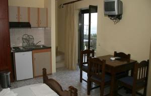 a kitchen and dining room with a table and a television at Anastasia Village in Nikiana