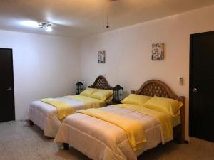 2 camas en una habitación con mantas amarillas en Apartamento&Habitación Galeana, en Ciudad Valles