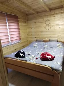 Bett in einem Holzzimmer mit zwei Kissen darauf in der Unterkunft Forest Lodge on the Pyramid in Visoko