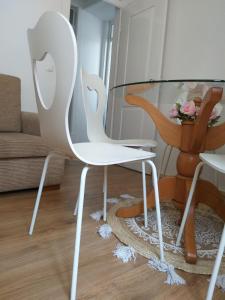 einen Glastisch und weiße Stühle im Wohnzimmer in der Unterkunft Farol de vida 2 in Coimbra