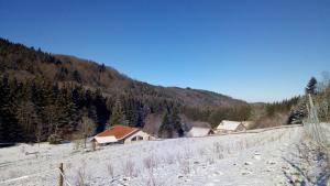 un champ enneigé avec des maisons et une montagne dans l'établissement La Hutte, à Tendon